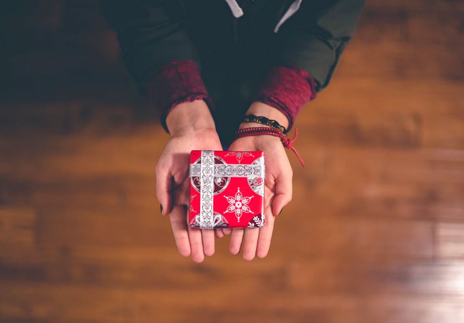 femme qui tient un petit cadeau dans ses mains